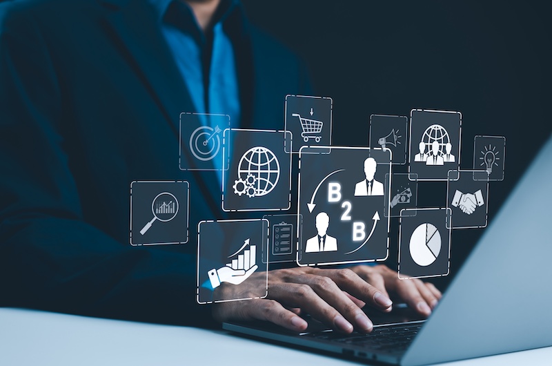 B2B business strategy concept. Businessman working with a B2B virtual interface on a laptop, conceptualizing strategy, partnership, targets in business to business services. E commerce, B2B Marketing,