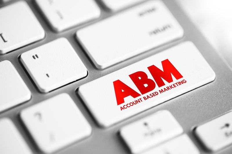 ABM Account Based Marketing business marketing strategy that concentrates resources on a set of target accounts within a market, text concept button on keyboard