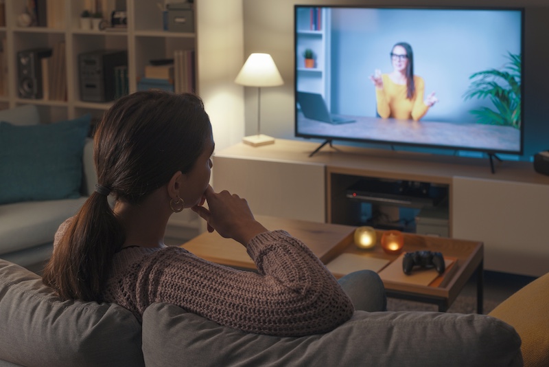 Woman watching an online course on her TV