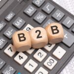 B2B letters on wooden cubes placed on calculator and financial spreadsheet