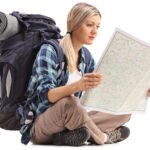 Female hiker sitting on the floor and looking at a generic map
