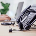 Communication support, call center and customer service help desk. telephone devices with VOIP headset in office.Customer service support (call center) concept.