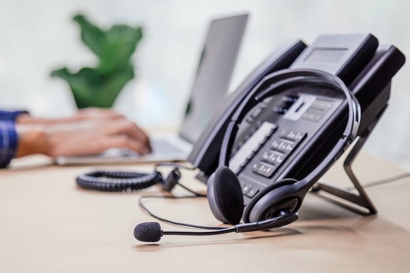 Communication support, call center and customer service help desk. telephone devices with VOIP headset in office.Customer service support (call center) concept.