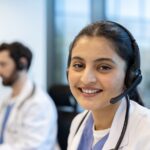 A smiling healthcare professional wearing a headset ready to assist and provide patient support.