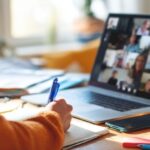 The person participating in a virtual meeting while taking notes.