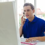 CallMiner Man operators with microphone and computer at work, Call center, support telemarketing.