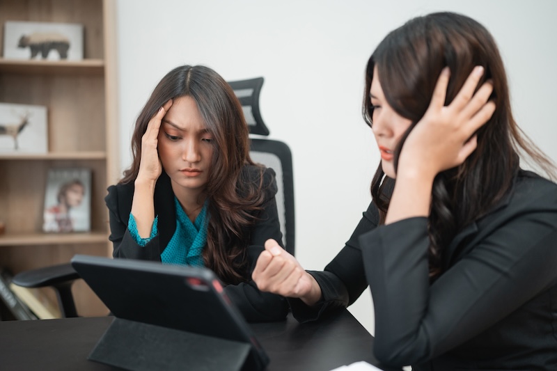 Hightouch Data Frustrated Businesswomen Analyzing Data on Tablet in Modern Office Setting