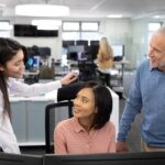 Senior businessman and two businesswomen working together at modern office