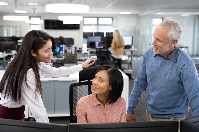 Senior businessman and two businesswomen working together at modern office