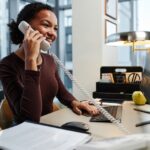 Young businesswoman answering phone calls at desk