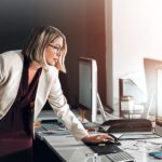 Aurasell AI GTM OS Computer, schedule and business woman in office planning, research or agenda, graph and solution. Pc, calendar or manager reading client feedback, review or b2b communication for project proposal