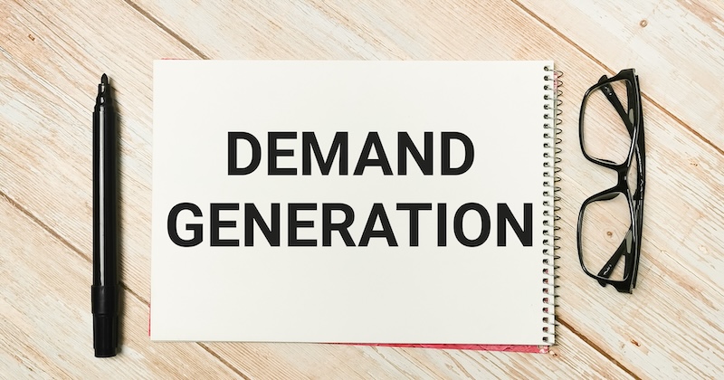 Vereigen Media Launches Revenue-First Demand Generation Programs Phrase demand generation written on note book with a marker pen and eye glasses.