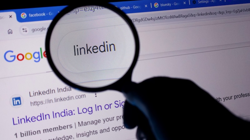 LinkedIn Is Emerging as AI Search Visibility Channel A magnifying glass showing linkedin on a computer screen with google search results