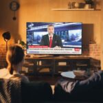 Wurl: Data Backs Advertising on Streaming News Channels Beautiful Couple Watching News On Television Set in Cozy Loft Apartment. Young Man and Woman are Catching Up With the Latest Events and Enjoying the Weekend in Tastefully Furnished Flat.